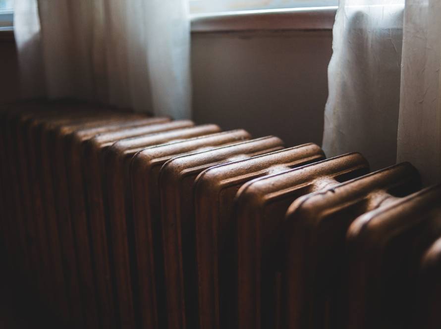 old radiator near windowsill at home in daylight